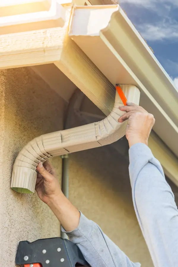worker-attaching-aluminum-rain-gutter-down-spout-to-fascia-o-worker-attaching-aluminum-rain-gutter-down-spout-to-fascia-86457994