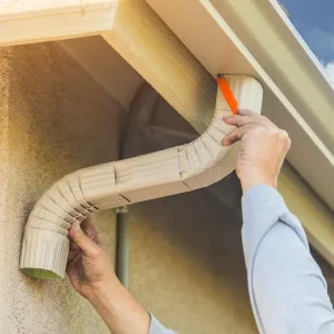 worker-attaching-aluminum-rain-gutter-down-spout-to-fascia-o-worker-attaching-aluminum-rain-gutter-down-spout-to-fascia-86457994